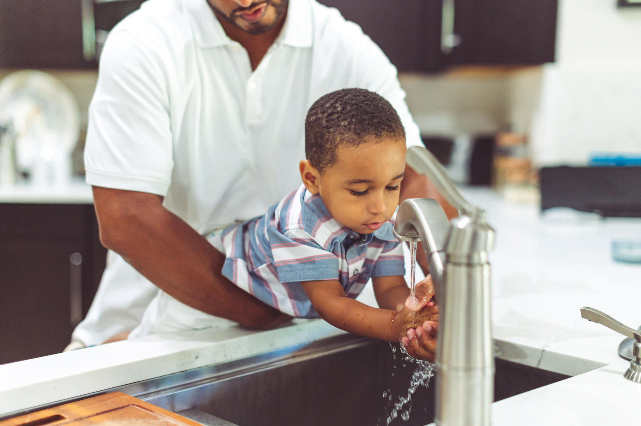 Father helping his child with handwashing.