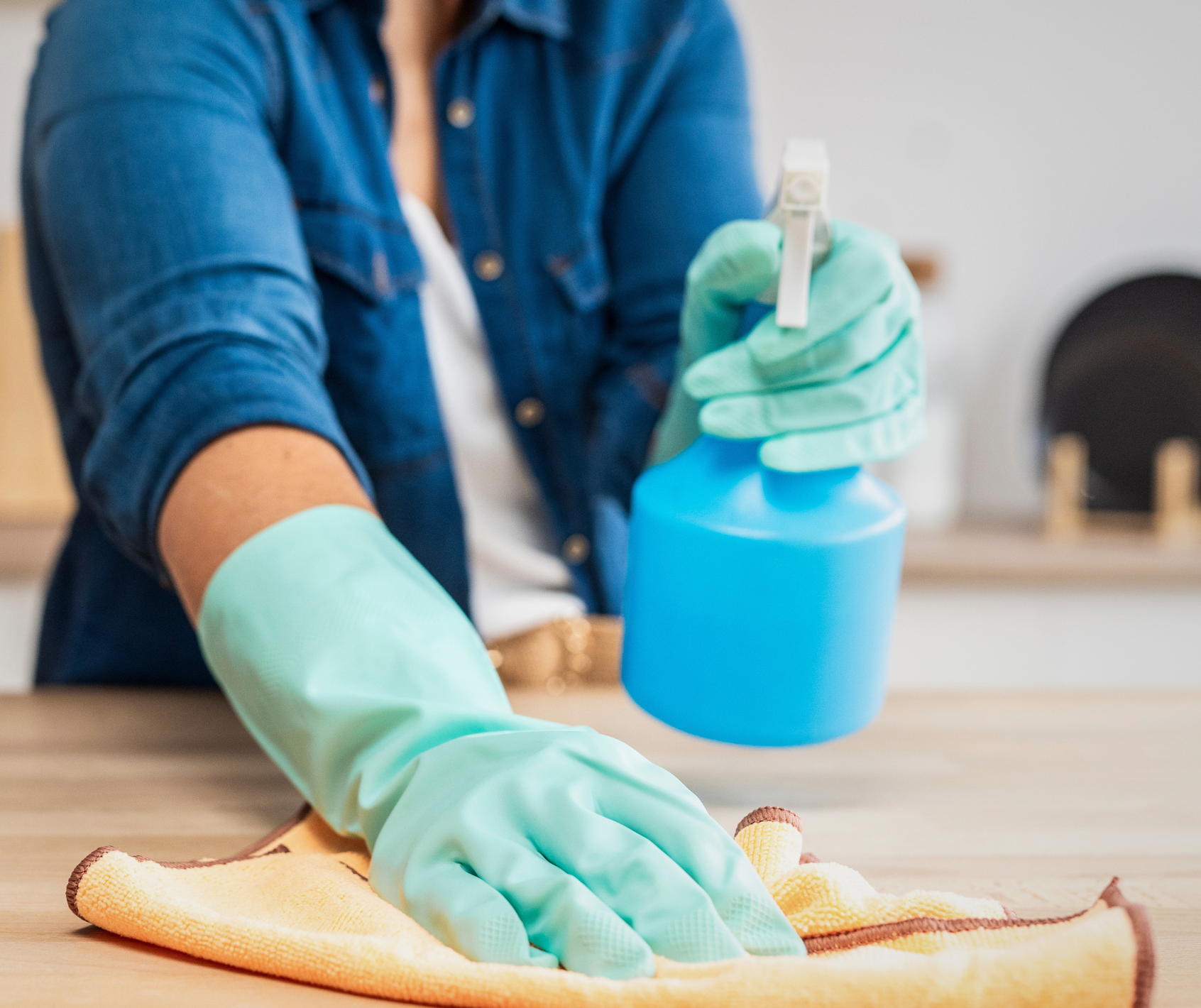 Person cleaning with a microfiber cloth and spray bottle.