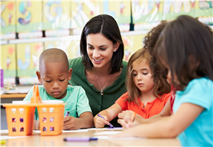 Small children sitting around a table with an adult