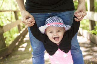 small baby walking with help of an adult