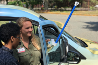 two people standing next to a data collector on a car
